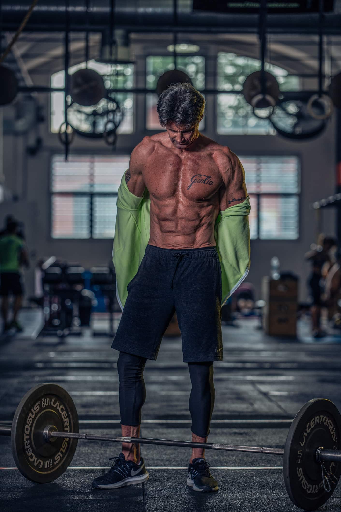 uomo muscoloso si toglie la felpa in palestra portfolio fotografo fitness
